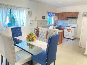 a dining room and kitchen with a glass table and chairs at Apto. Luxury con Piscina “Brisa del paraíso¨ in Concepción de La Vega