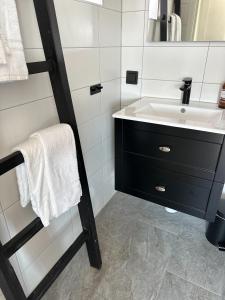 La salle de bains est pourvue d'un lavabo et d'un miroir. dans l'établissement Hotell Käringön, à Käringön
