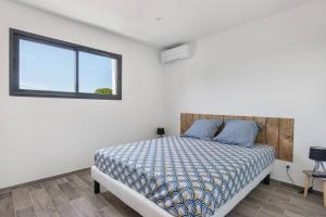 a bedroom with a bed and a window at Villa MOON - 600m plage - clim - 6 pers - Cap d'Agde in Cap d'Agde