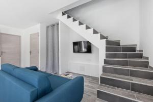 a living room with a blue couch and stairs at Villa MOON - 600m plage - clim - 6 pers - Cap d'Agde in Cap d'Agde