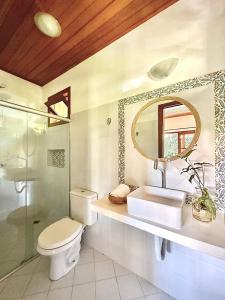 a bathroom with a toilet and a sink and a mirror at Aldeia dos Corais - Taipu de Fora in Barra Grande