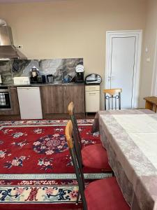 - une cuisine avec un lit et un tapis rouge dans la chambre dans l'établissement Допълнителна къща за гости Ози 1, à Ovchartsi