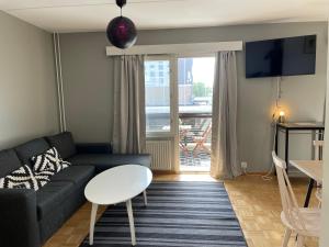 a living room with a couch and a table at Tapiola City Apartment in Espoo