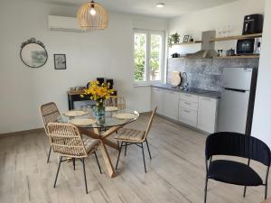 Una cocina y un comedor con mesa y sillas. en Apartmani Šara 2, en Betina