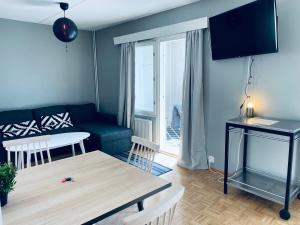 a living room with a couch and a table at Tapiola City Apartment in Espoo