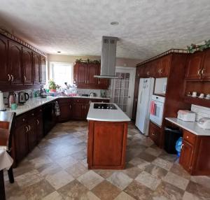 a kitchen with wooden cabinets and a white refrigerator at Diana's Beauty House in Charlottetown