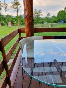a glass table on a wooden deck with a playground at Відпочинок у Закарпатті in Kushnytsya