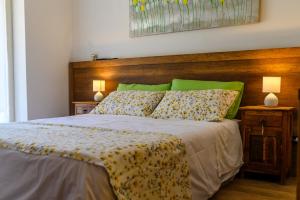 ヴィッランマレにあるLa tela di Penelopeのベッドルーム1室(ベッド1台、木製ヘッドボード、ランプ2つ付)