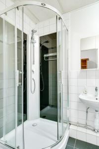 a glass shower in a bathroom with a sink at Hotell Hof in Örebro