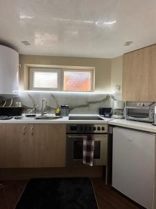 a kitchen with a sink and a stove top oven at Допълнителна къща за гости Ози 2 in Ovchartsi