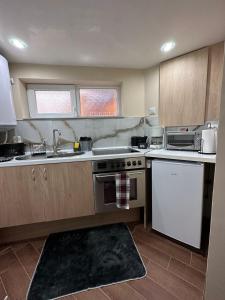 a kitchen with a sink and a stove top oven at Допълнителна къща за гости Ози 2 in Ovchartsi