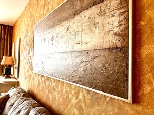 ein Gemälde an der Wand eines Zimmers mit einem Sofa in der Unterkunft Swiss Central Luxury Apartment 132m2 in Sarajevo
