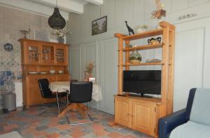 a living room with a tv and a table with chairs at monumentaal huisje Bed & Meer in Veere