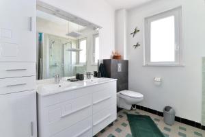 a white bathroom with a sink and a toilet at Le gîte de Vitazensel in Logelbach