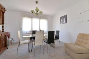 a dining room with a table and chairs and a couch at Le gîte de Vitazensel in Logelbach