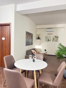 ein Wohnzimmer mit einem weißen Tisch und Stühlen in der Unterkunft La casa di Apollo in Acireale