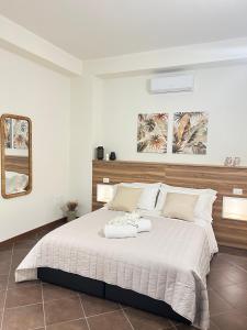 ein Schlafzimmer mit einem großen Bett mit zwei Handtüchern darauf in der Unterkunft La casa di Apollo in Acireale