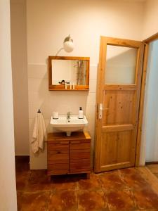 baño con lavabo, espejo y puerta en Heltau Apartments, en Cisnădie