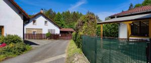 a house with a fence next to a driveway at Apartmán na Koskách in Třeboň