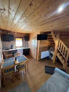 a kitchen and living room of a log cabin at Domki Teo - Rewal in Rewal
