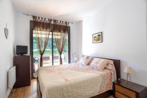 a bedroom with a bed and a large window at Apartments Sa Boadella, Lloret de Mar - Costa Brava in Lloret de Mar