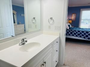a bathroom with a sink and a mirror at Salt, Sand and Sudds home in Holden Beach