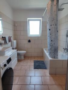 y baño con bañera, aseo y lavamanos. en Best Buy Apartments Fažana Valbandon, en Fažana