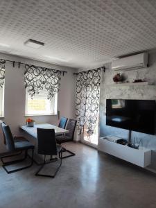 sala de estar con mesa y TV de pantalla plana en Best Buy Apartments Fažana Valbandon, en Fažana