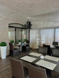 a dining room with tables and chairs and a chandelier at Family Hotel Paradise in Saints Constantine and Helena