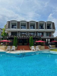 un hotel con piscina di fronte a un edificio di Family Hotel Paradise a Sveti Konstantin i Elena