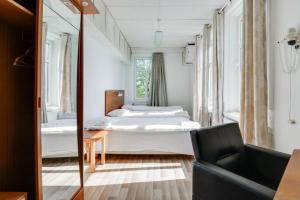 1 dormitorio con cama y espejo en Hotell Hof en Örebro