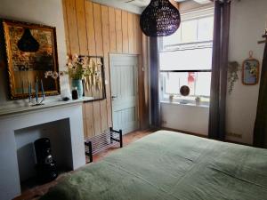 a bedroom with a large bed and a fireplace at monumentaal huisje Bed & Meer in Veere