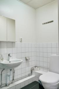 a white bathroom with a sink and a toilet at Hotell Hof in Örebro