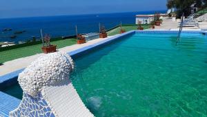 a swimming pool with the ocean in the background at La Dea del Mare in Ischia