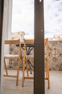 uma mesa e cadeiras numa varanda com vista em B&B DOMUS DEIANAS em Cagliari