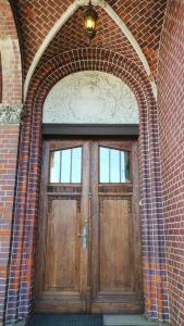 an archway with a wooden door in a brick building at Willa "Hel" in Krynica Morska