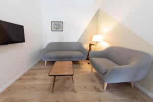 uma sala de estar com duas cadeiras e uma televisão em B&B DOMUS DEIANAS em Cagliari