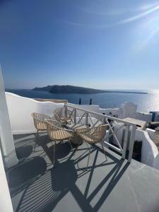 a group of chairs and tables sitting on a roof at The Sunset Windmill in Oia