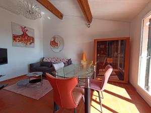 uma sala de estar com uma mesa de vidro e cadeiras em Villa 3 chambres vue mer Valcros em La Londe-les-Maures