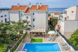 an apartment with a swimming pool and a view of the ocean at Villa Mirela in Petrcane