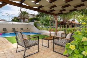 a patio with chairs and a swimming pool at Villa Mirela in Petrcane