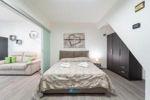 un dormitorio con una cama y un sofá en City Center white, en Alghero
