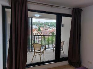 een kamer met een raam met uitzicht op een balkon bij Cosmopolit by Riba in Braşov