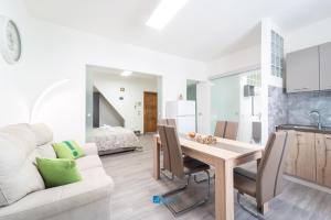 Una cocina y una sala de estar con una mesa y un sofá. en City Center white, en Alghero