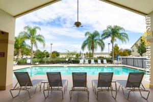 basen z krzesłami i stołem oraz basen w obiekcie 3BR Apartment near Disney w mieście Kissimmee