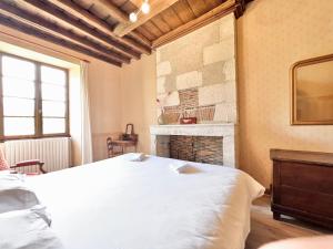 a bedroom with a white bed and a fireplace at Au Domaine Valigny, piscine chauffée + WIFI Fibre in Saint-Benoît