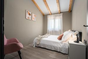 a bedroom with a bed and a chair and a window at Casa Pinia with outdoor jacuzzi in Poreč
