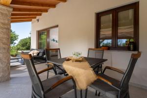 Casa Pinia with outdoor jacuzzi في بوريتش: غرفة طعام مع طاولة وكراسي