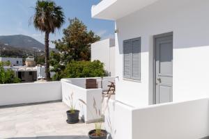 Cette maison blanche dispose d'un balcon avec vue. dans l'établissement Galinos Hotel for adults only, à Parikia