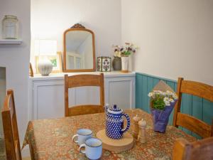 tavolo da pranzo con vaso bianco e blu di Allington Cottage a Bridport